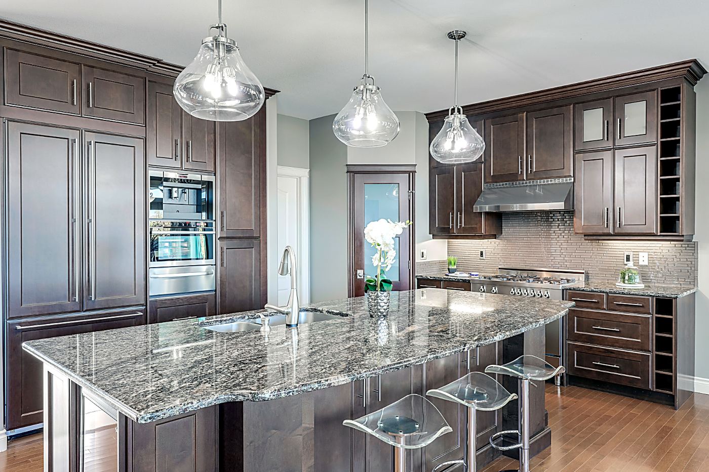 Granite island countertop in a dark walnut kitchen